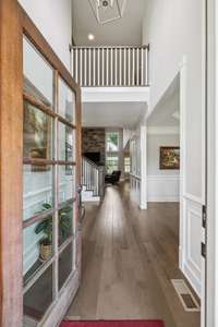 The Foyer leaves a lasting first impression. As you pass through the 10-light wood door with sidelights and arched transom, you are welcomed by a stunning 2-story ceiling with brushed nickel chandelier.