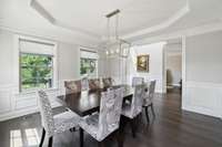 The spacious Dining Room connects to the Kitchen through a Butler’s Pantry. Notable features include a tray ceiling, an elegant chrome light fixture, chair rail with wainscot, and fluted cased openings.