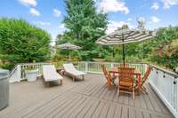 A sizable Deck overlooks a serene backyard with mature trees and extensive landscaping.