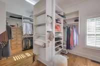 Primary closet contains wooden built-ins for maximum organization