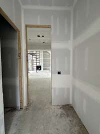 Mud Room convenient to th kitchen and drop zone. Utility Room with custom cabinetry, sink, broom cabinet, hanging rod and Mud Room convenient to th kitchen and drop zone.  This home is under construction. Photo taken: 9/14/24