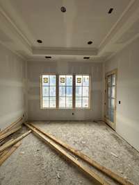 Bedroom #4 connected decorative glass doors to a covered deck. *this home is under construction. Photo taken 9/14/24