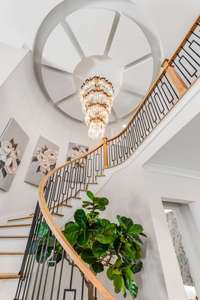 Stunning staircase with high end show exquisite chandelier and detailed ceiling treatment!