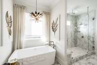 Relaxing extra large soaking tub under natural light.  Shower has rainhead!