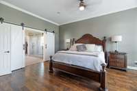 The primary suite is located on the first floor and the hardwoods extend into the bedroom.