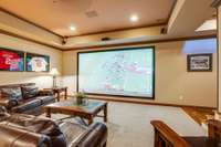 Basement features full wall projector TV for movie nights and plenty of open space for lounging