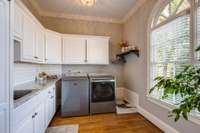 Enjoy the functionality in the over-sized laundry room featuring granite counter tops, tons of cabinets and arched windows that fill the space with natural light