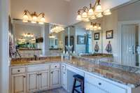 Indulge in the expansive master bathroom featuring a large soaking tub and separate his and her vanities and separate walk in closets