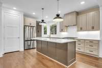 Another view of the kitchen island, refrigerator & pantry.