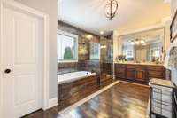 Primary bathroom features a large soaking tub, walk in shower and large dual vanities.