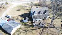 View of home from the back. Left side of the picture is the detached garage with carport. Small building in center is the original smoke house, now used as a shed.