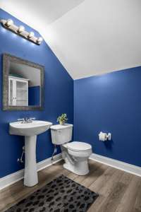 Convenience meets style in the half bathroom, featuring modern fixtures, sleek design, and an unexpected pop of color to wow your visitors. This well-placed space adds functionality to your home, perfect for guests and quick refreshes.