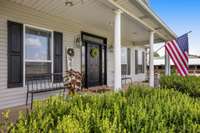 Welcome to your inviting farmhouse, where rustic charm meets modern sophistication. Imagine suntea in the afternoons here. This welcoming covered porch opens to a warm and cozy interior, setting the tone for the comfortable living that awaits inside.