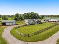 The impressive barn exterior showcases the heart of this equestrian property. Well-maintained and fully equipped with ample stalls and top-tier amenities, the barn is designed for the function and comfort of both you, your horses and farm animals.