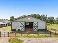 The rear exterior of the barn showcases its expansive design and easy access to the pastures. It’s a perfect setup for efficient management and care of your animals.