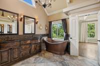 Elegant copper soaking tub is a focal point of this primary bath.