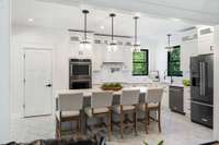 The kitchen features beautiful tile flooring that adds both style and practicality, with its easy-to-clean surface and elegant design complementing the overall aesthetic of the space. A large walk-in pantry is a standout feature of this kitchen.