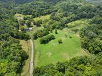 The expansive pastures are lush and well-maintained, providing open, grassy fields perfect for grazing horses or other livestock.