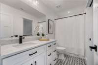 The two full bathrooms upstairs are elegantly finished with tile floors and stone countertops, reflecting the high-quality materials found throughout the home.