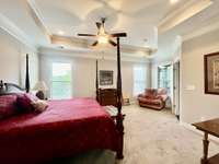 Primary Suite with crown molding trey ceiling recessed lighting ceiling fan; Has sitting area-great for reading nook.