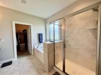 Primary Bath Suite with double vanities with marble tops; garden tub and tile shower; walk in closet