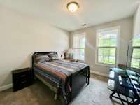 Front bedroom on main level overlooking the front yard; Carpet flooring; Home has 3 bedrooms 3 full baths