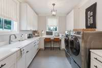 You will almost want to do laundry in this working laundry room with tons of light, sink, built ins and again, tons of storage.