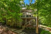 A paver walkway wraps completely around the home. An exterior staircase provides easy access to the lower level hot tub.