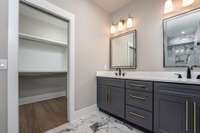 Primary Bedroom's Ensuite Bathroom featuring Italian Tile Surround Shower and floor with Dual Quartz Vanities with lighted Mirrors and luxury accent lighting sconces. Walk-in Closet.