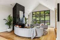 The expansive window overooks the lovely backyard enclave beyond.  The vaulted ceilings here are a beautiful architectural enhancement.