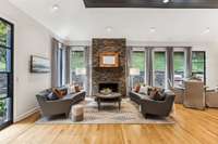 The stone fireplace in the den anchors this beautiful space.  The wall of windows at the back of the den and kitchen dining area allow for magnificent views from every angle.