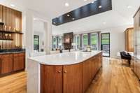 The wet bar on the left side of this picture boasts a stylish accent feature wall and decorative floating shelving.