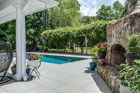 A daytime view of the the extended patio, pool & stone fireplace.  Plus a better view of the amazing arbor...picture that in the spring time with huge white blossoms!