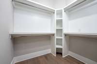 Primary Walk-In Closet with custom shelving for shoes.