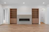 Linear gas fireplace with quartz surround and built-ins that match the kitchen