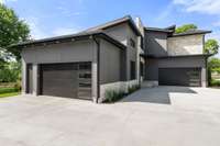 The garage on the left features a pedestrian door. There is ample room for parking lots of cars in the driveway and still maintaining drive through access - great for parties and events.