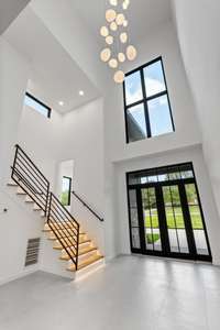Two story foyer with cascading pendant light fixture.