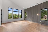 Primary suite with feature wall trim details and vaulted ceiling