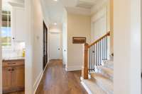 Hallway leading to Utility Room, Powder Room, 2nd and 3rd Bedrooms and upstairs area.