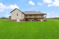 The back deck and covered porches are perfect for entertaining or just relaxing and enjoying the view of your spring fed pond.  *The grass color is enhanced*  The owner has planted new grass, It is growing in nicely but not fully in.