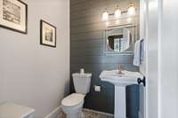 The Powder Room has the most perfect color Blue Shiplap wall and uniquely paired custom tile floor.