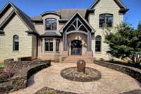 Grand entrance with circular stone front terrace and water feature.