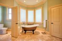 Gorgeous copper finish soaking tub situated in front of bay window. Shades have remotes to provide yet another beautiful view outside.