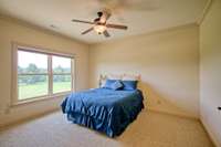 Upstairs guest room with double window and views of property.