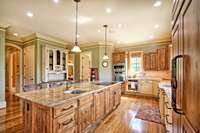 View of kitchen, island, and access door to elevator. Note the Island sink that is in addition to the main sink and has a second garbage disposal.