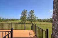 Private side deck from Primary bedroom with views of sideyard and small orchard.