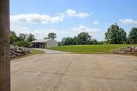 View from 3-car garage of expansive driveway and equipment shed.