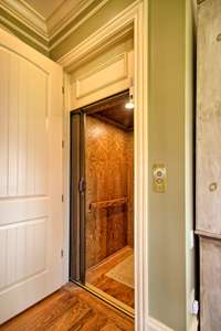 Gorgeous, richly paneled wood elevator is fully operable and accesses all three floors.