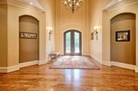 Iron front doors are offset by stylish molding and arched niches.