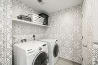 Laundry room with shelving and storage closets.